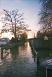 Picture of the lane, flooded and looking like a smaller version of the river next to it.
